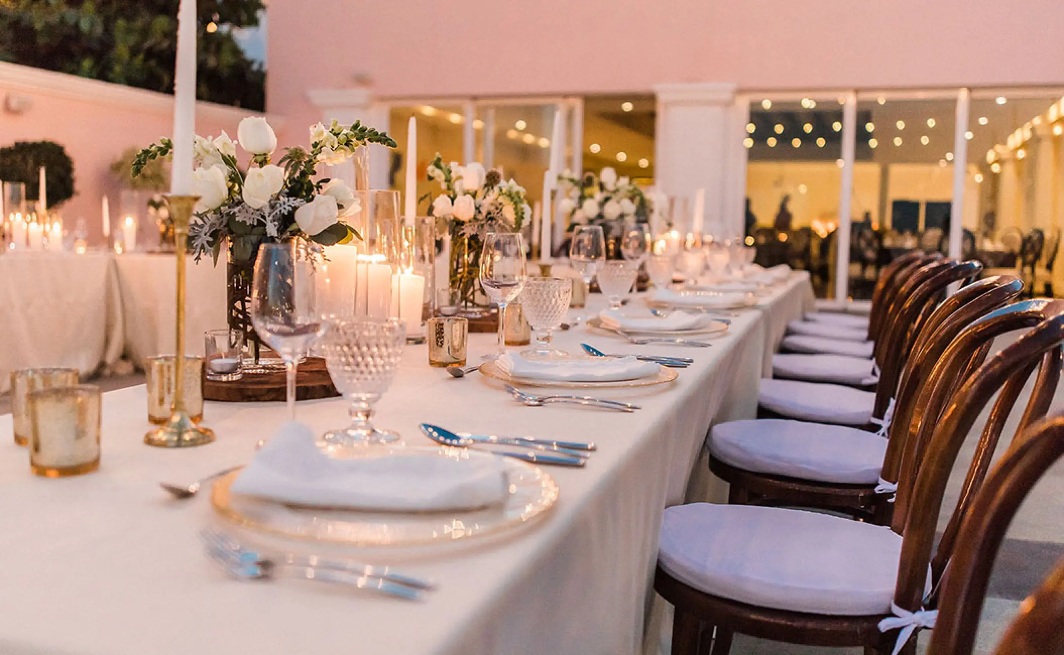 Outdoor wedding reception setup with candlelight and white floral centerpieces at Pueblo Bonito Rose, Cabo San Lucas