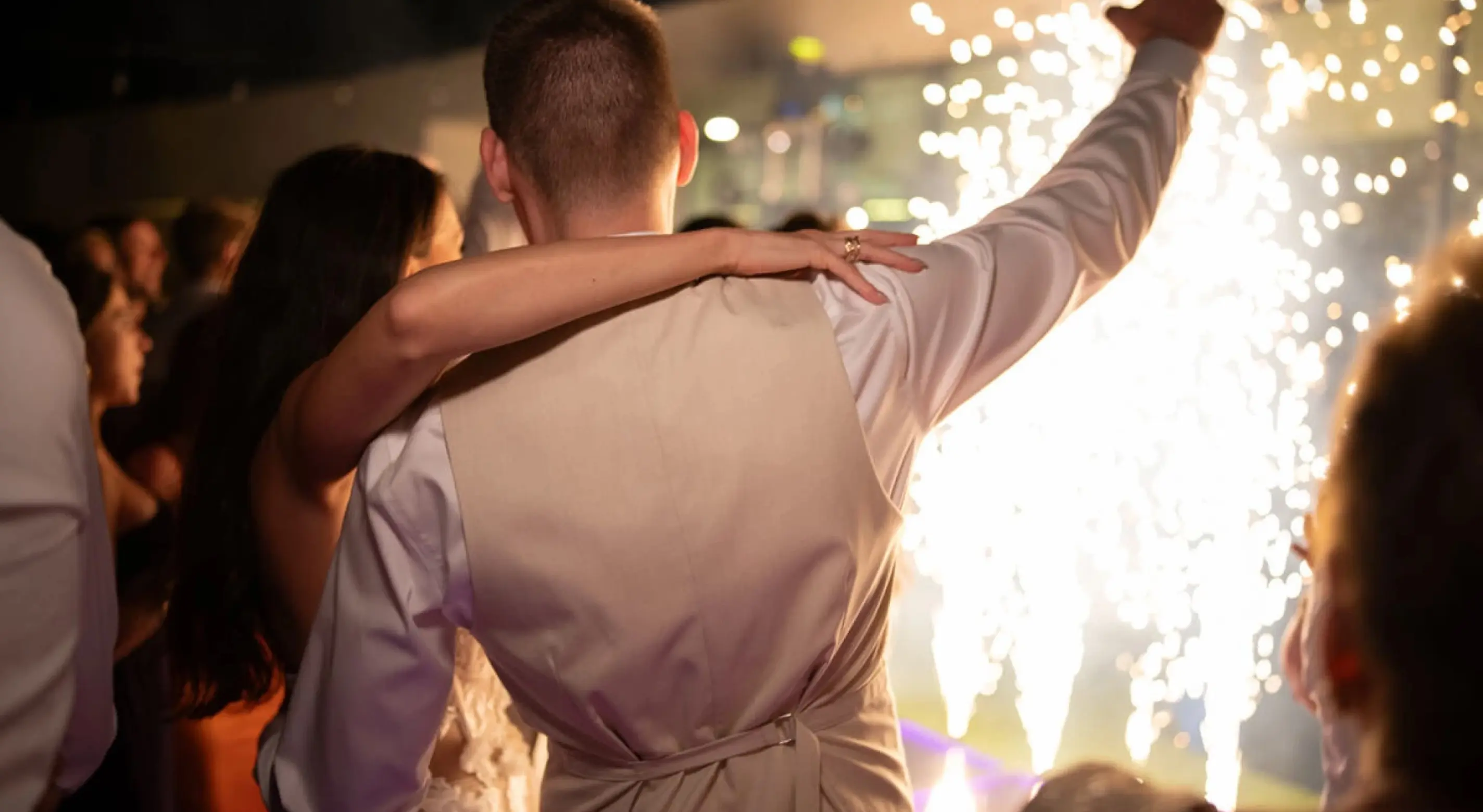 Newlyweds celebrating with cold spark fireworks during a destination wedding reception