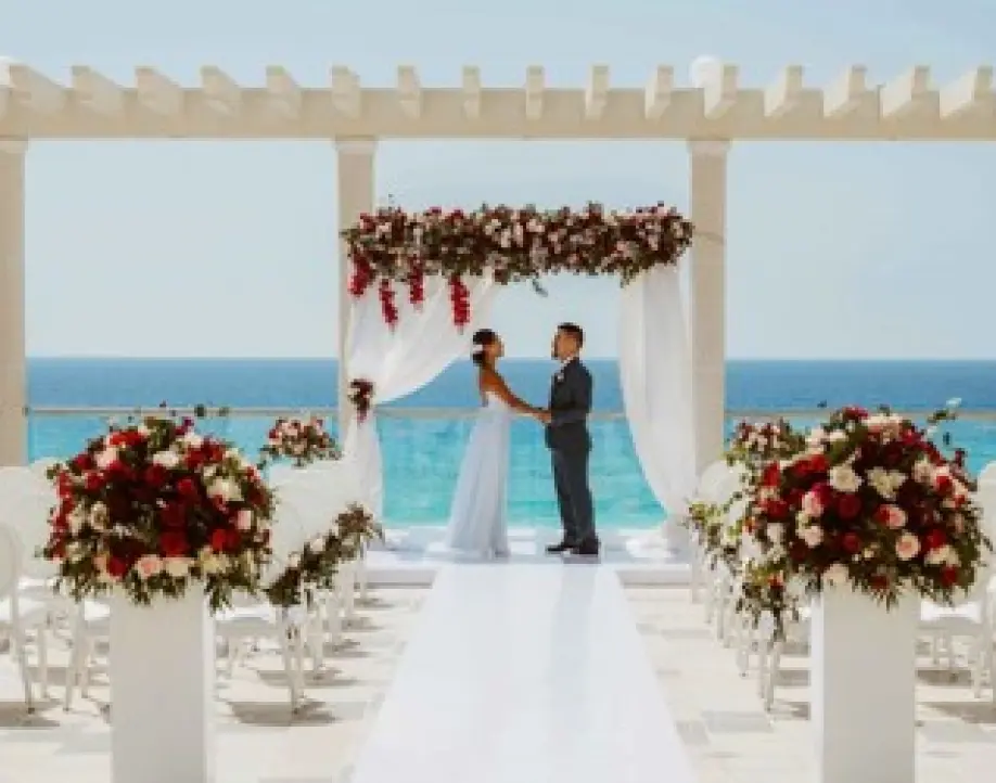 The couple holding hands during an oceanfront terrace wedding ceremony in Cancun