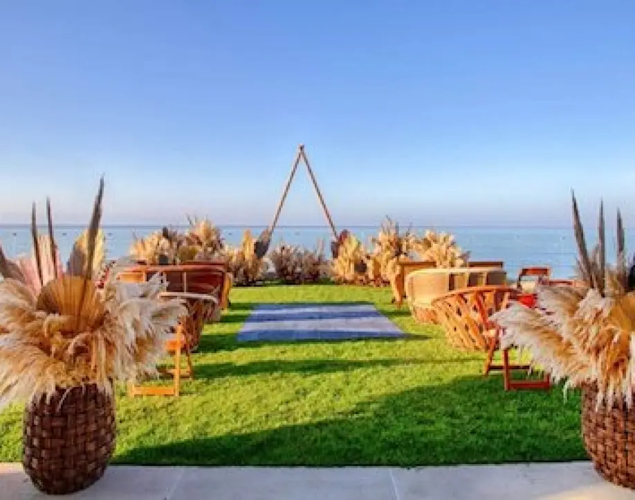 Garden wedding ceremony setup with pampas grass and triangular arch overlooking the ocean in Puerto Vallarta
