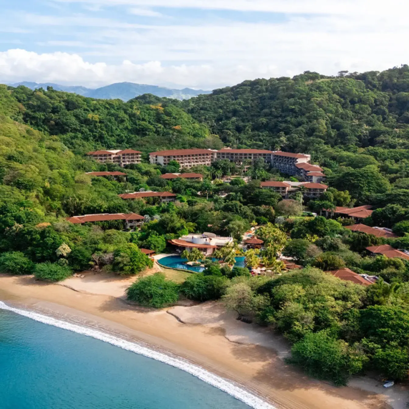 Aerial view of Dreams Las Mareas between lush rainforest and a secluded beach, Costa Rica