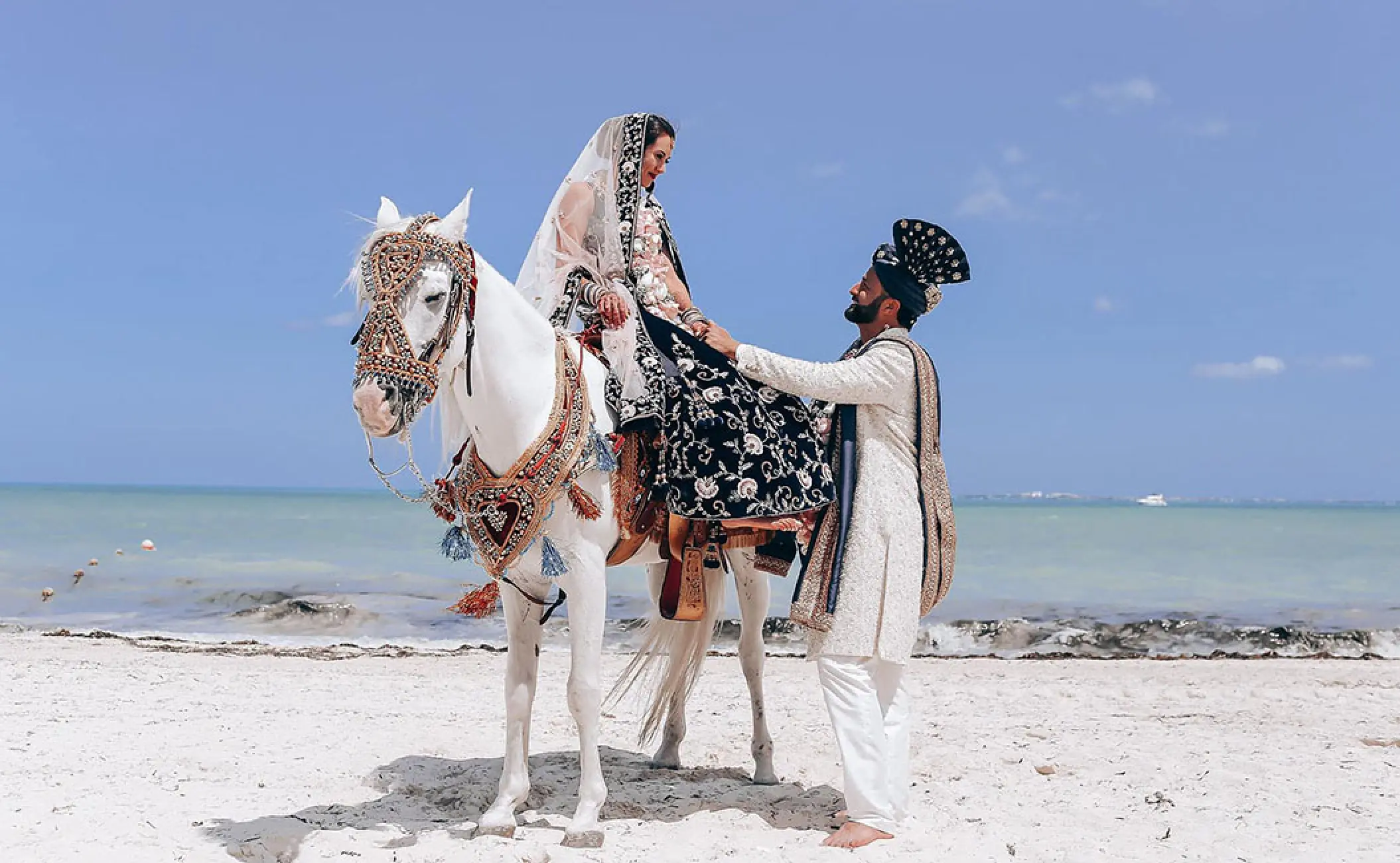 South Asian wedding ceremony with a bride on a white horse at Atelier Playa Mujeres, Cancun