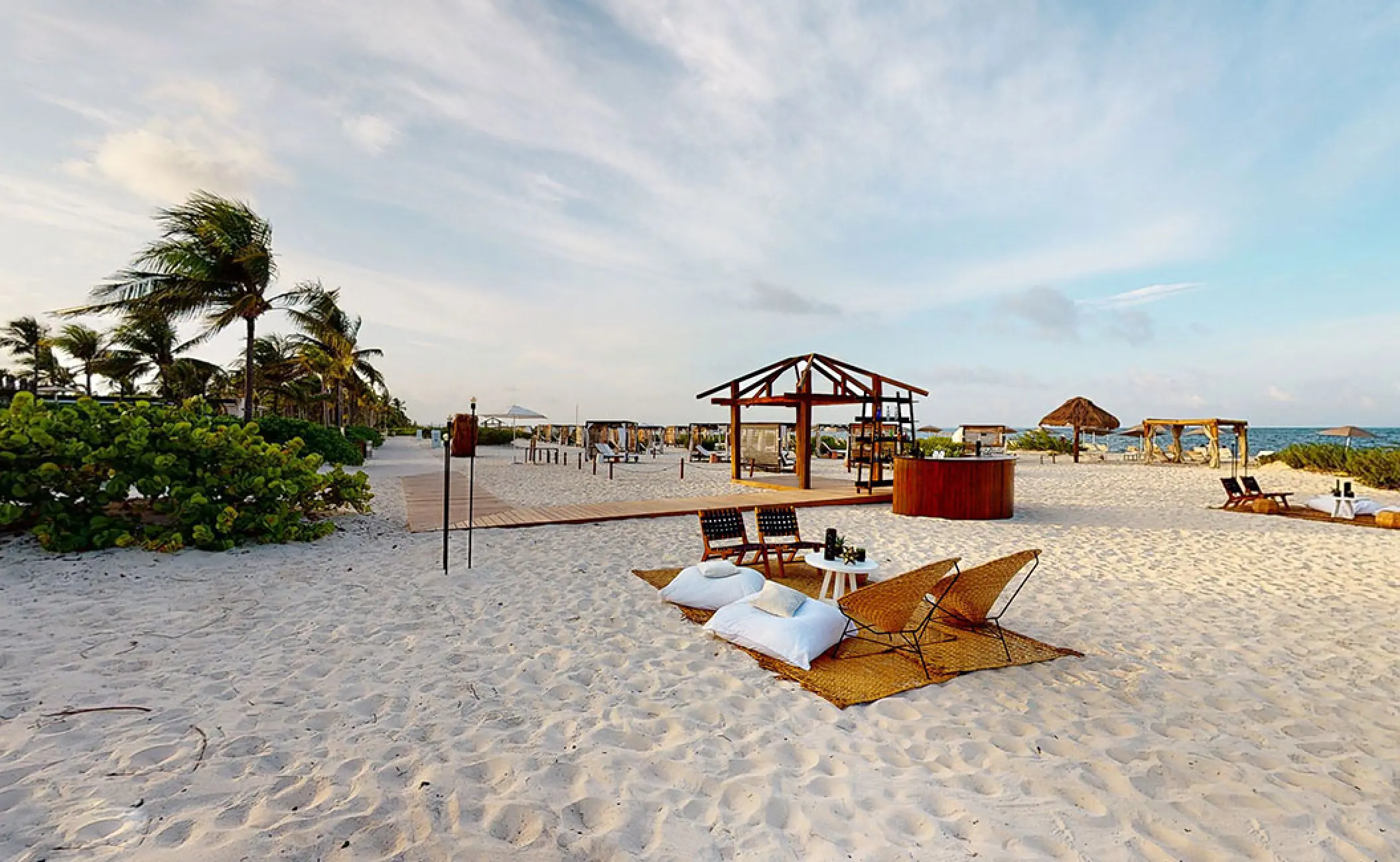 Lounge seating and wooden structures for a beach ceremony at Atelier Playa Mujeres, Cancun