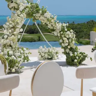 White floral arch at an outdoor wedding ceremony at Atelier Playa Mujeres, Cancun