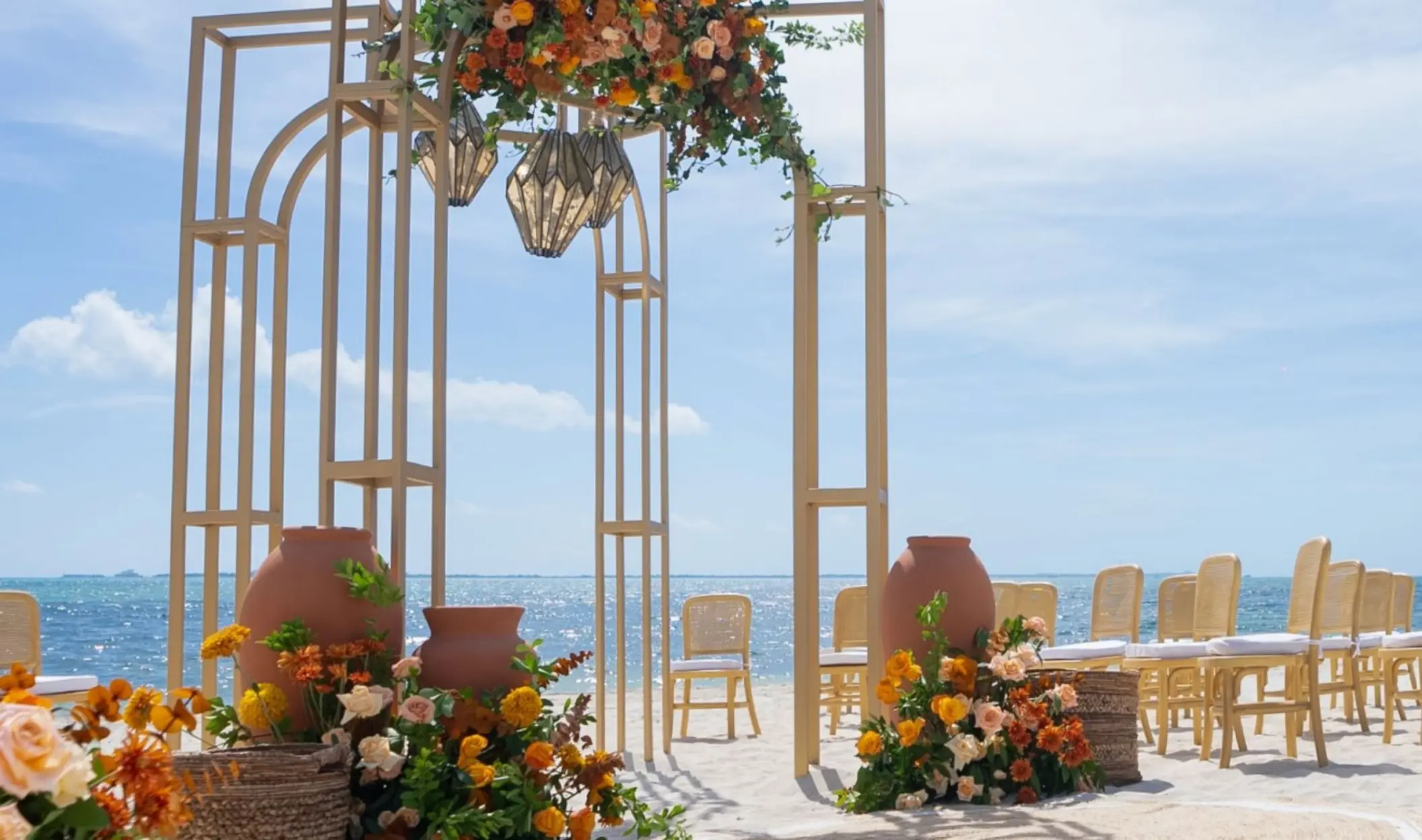 Solara beach wedding ceremony setup with earthy floral accents at Atelier Playa Mujeres, Cancun
