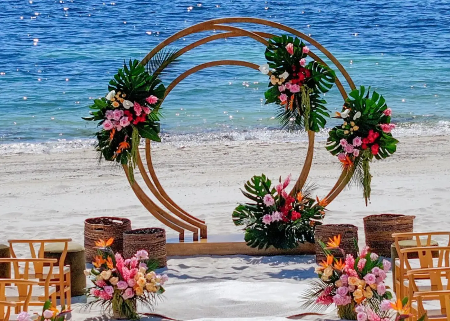Circular beach wedding ceremony arch with tropical flowers at Atelier Playa Mujeres, Cancun