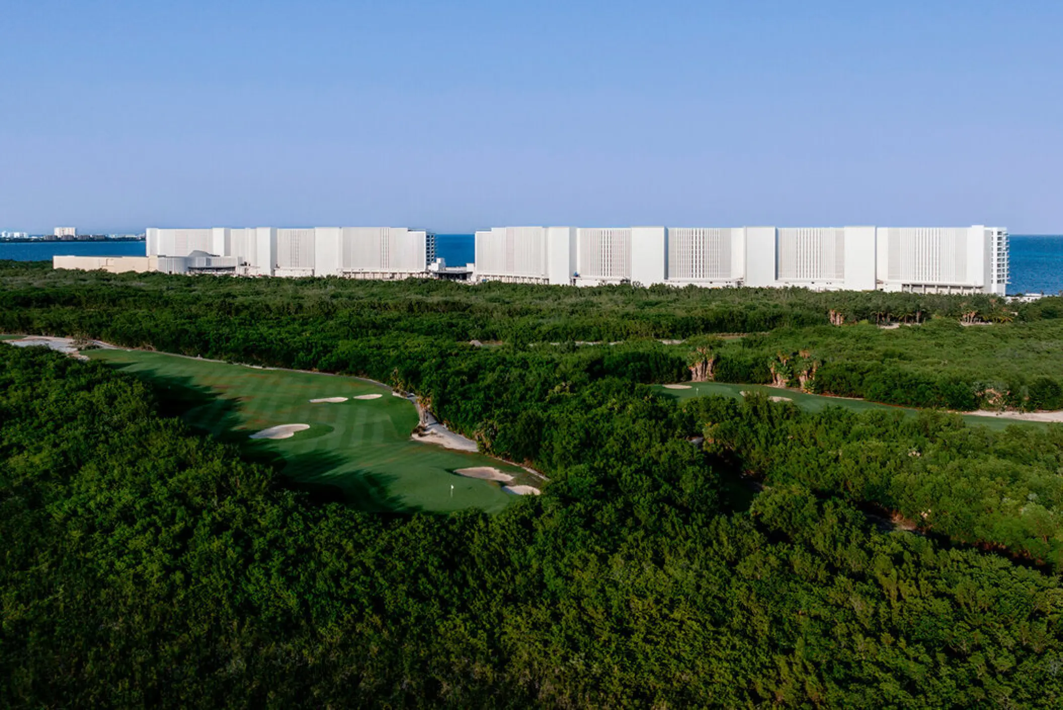 Aerial view of AVA Resort Cancun buildings and golf course surrounded by lush greenery, Cancun