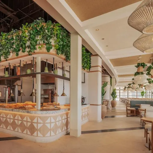 Modern buffet area and dining room with hanging greenery and wicker lamps at AVA Resort Cancun, Cancun