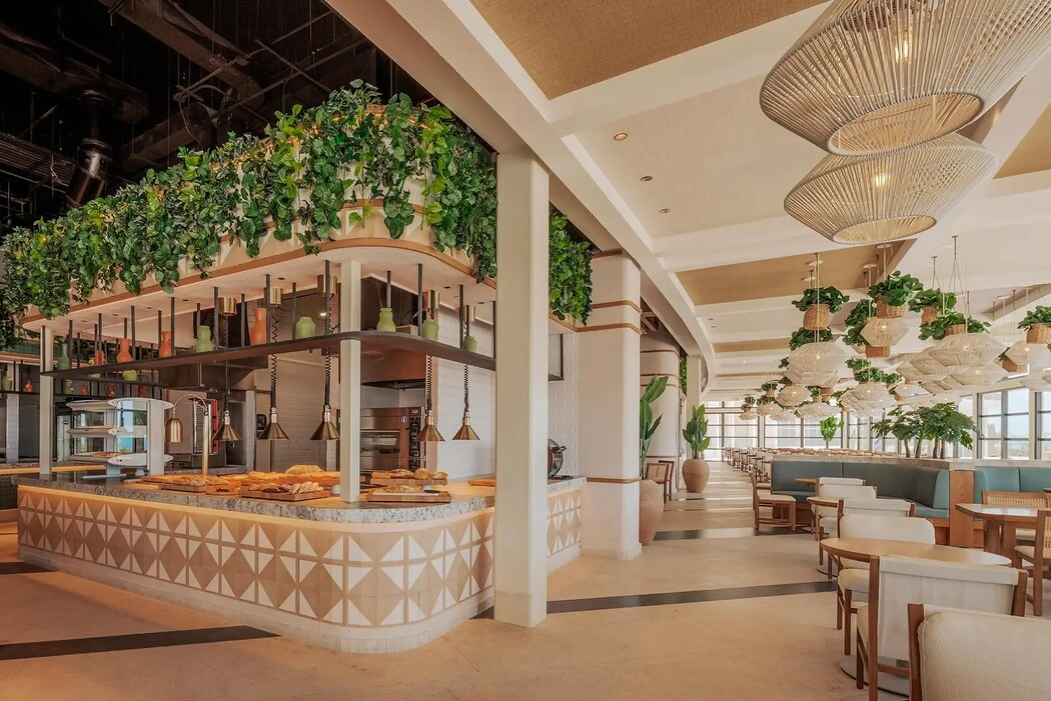 Modern buffet area and dining room with hanging greenery and wicker lamps at AVA Resort Cancun, Cancun