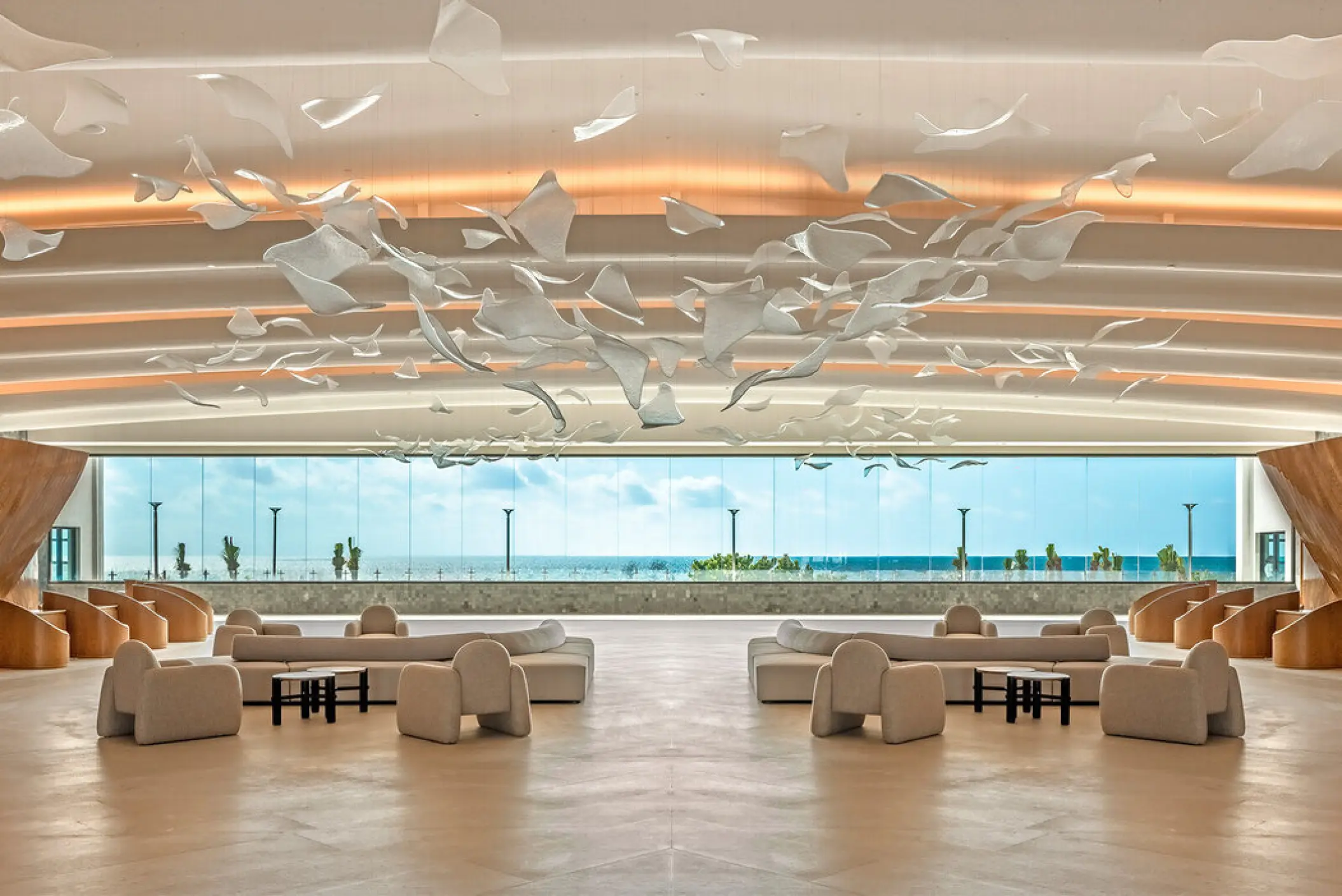 Modern open-air lobby with sculptural ceiling art and ocean views at AVA Resort Cancun, Cancun