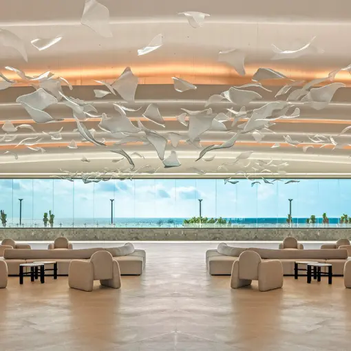 Modern open-air lobby with sculptural ceiling art and ocean views at AVA Resort Cancun, Cancun