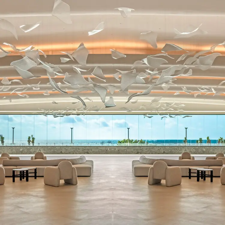 Modern open-air lobby with sculptural ceiling art and ocean views at AVA Resort Cancun, Cancun