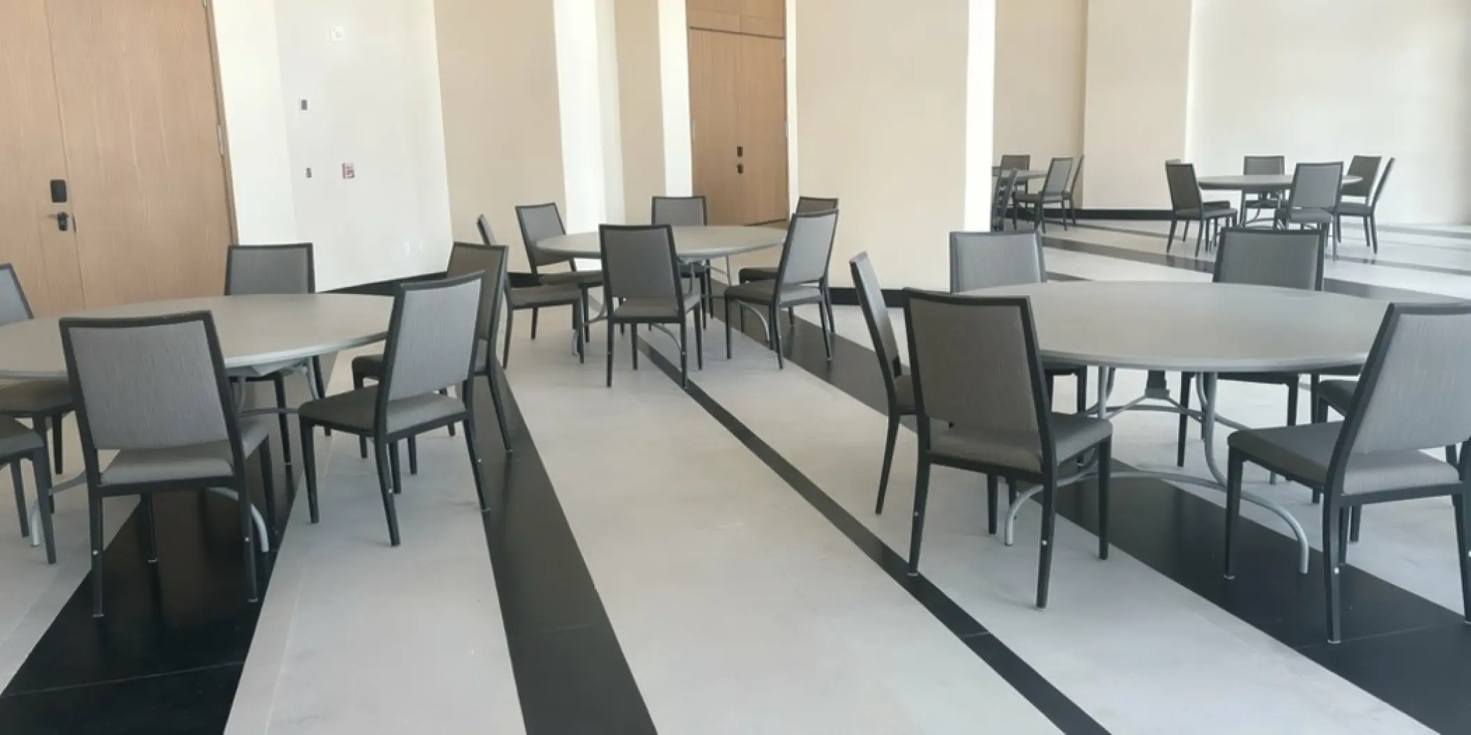 Modern ballroom wedding reception setup with round tables and grey chairs at AVA Resort Cancun