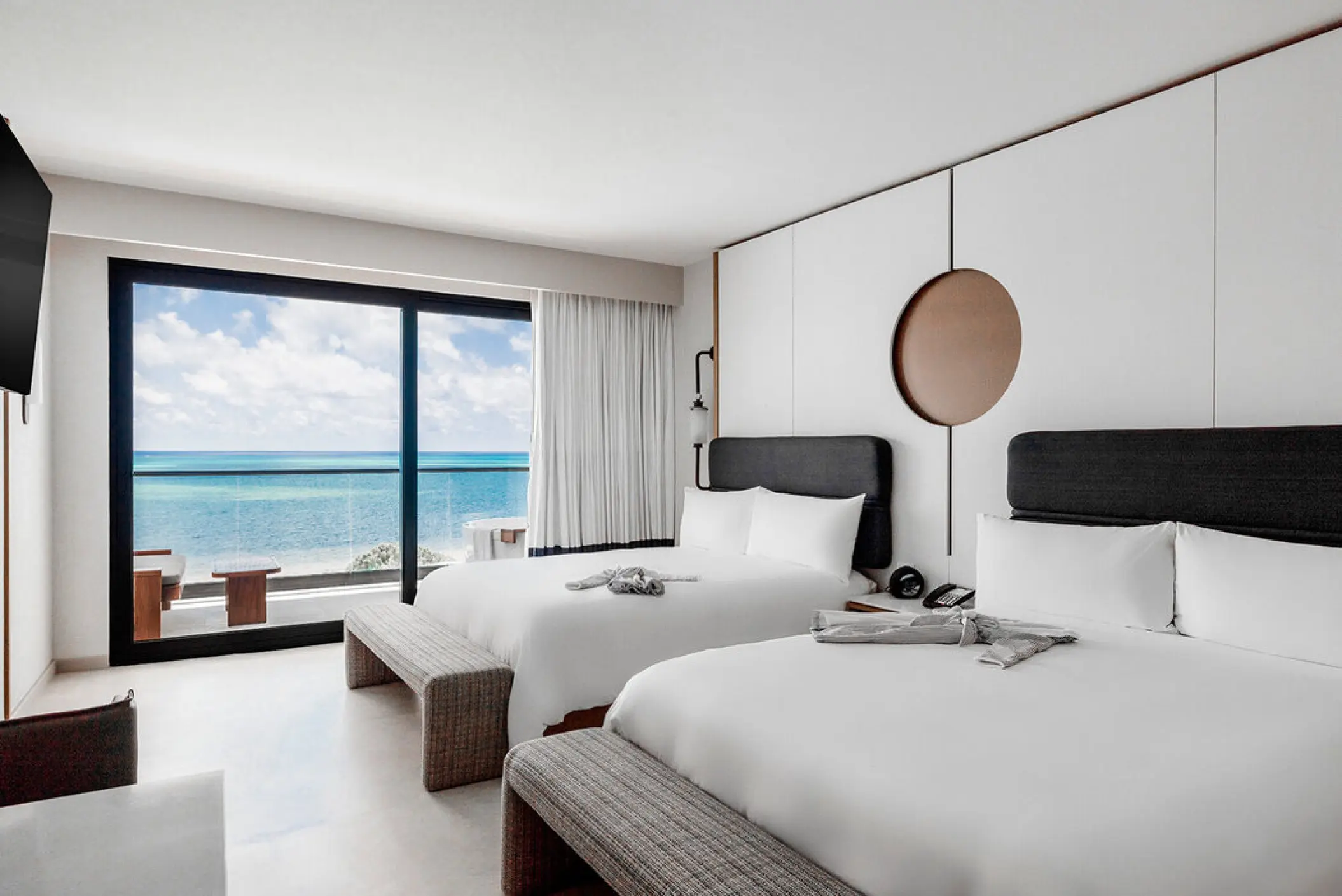 Modern guest room with two double beds and ocean view balcony at AVA Resort Cancun, Cancun