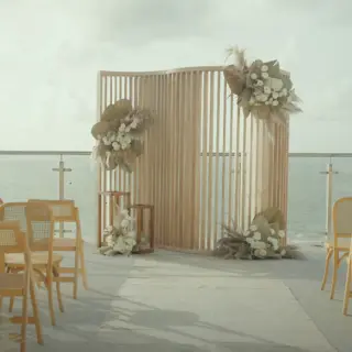 Terrace wedding ceremony at AVA Resort Cancun with ocean views and floral wooden backdrop, Cancun