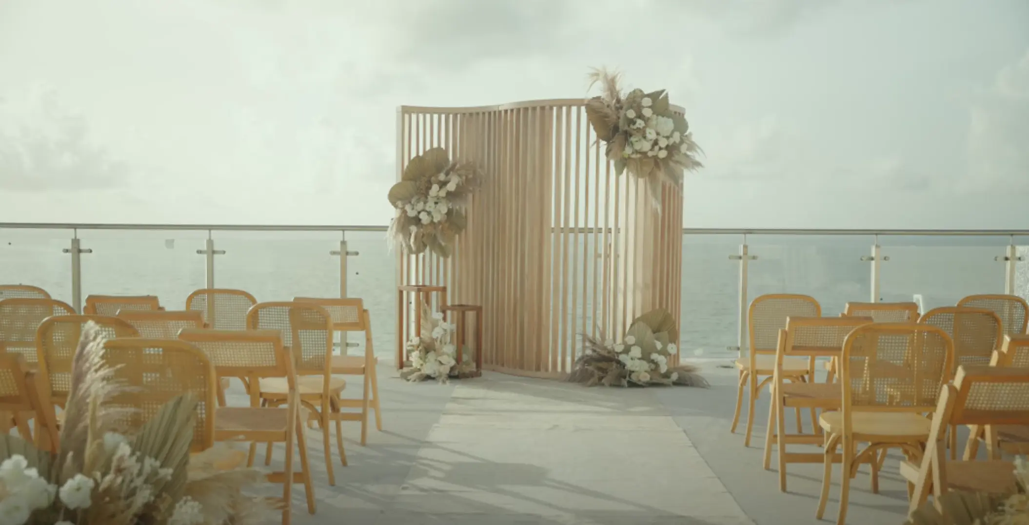 Terrace wedding ceremony at AVA Resort Cancun with ocean views and floral wooden backdrop, Cancun