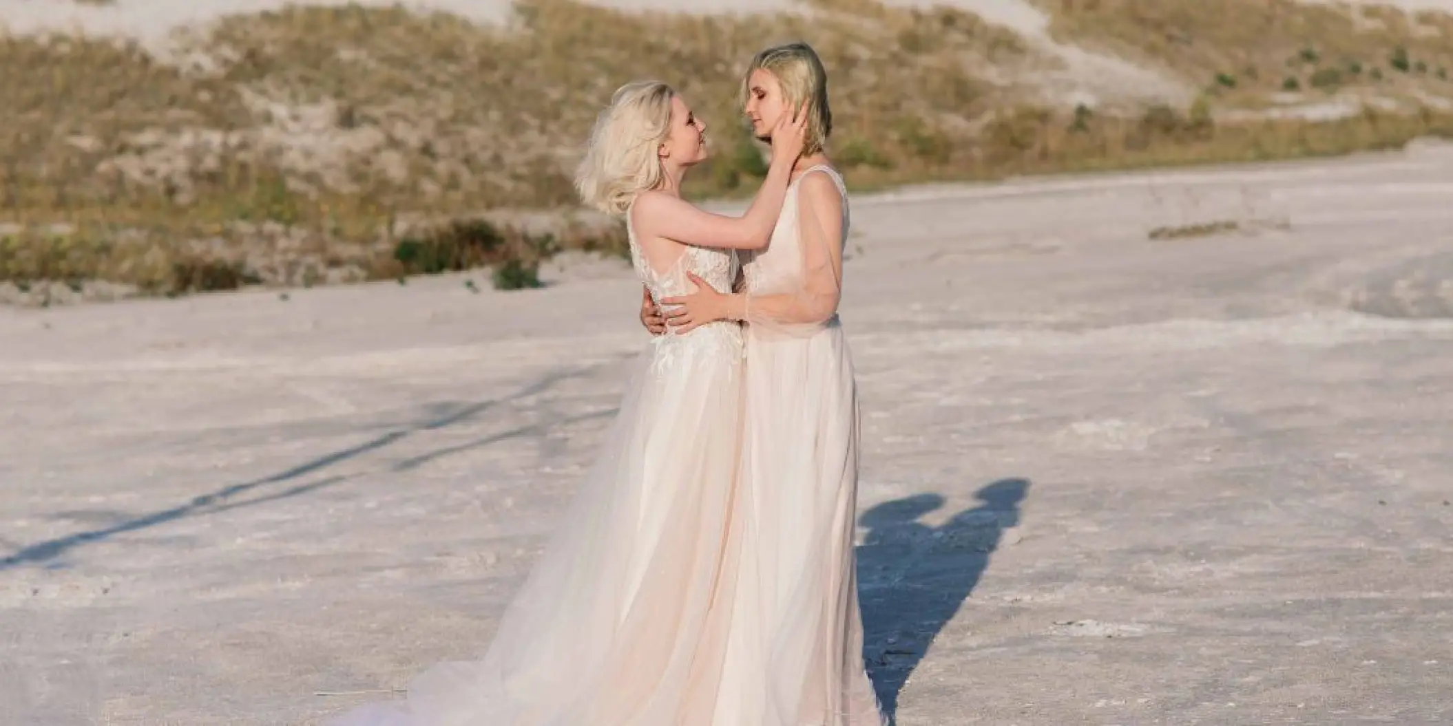 Two brides embracing during their wedding at Bahia Principe Sian Ka’an, Tulum