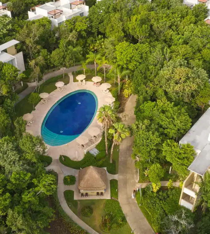 Aerial view of the oval swimming pool and jungle grounds at Bahia Principe Luxury Sian Ka’an, Tulum