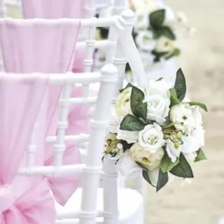 White chiavari chairs with pink sashes and white floral bouquets for a wedding at Bahia Principe Sian Ka’an, Tulum