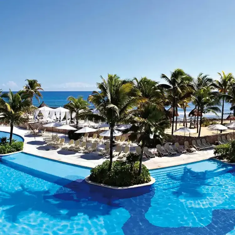 Bahia Principe Luxury Akumal swimming pools and palm trees overlooking the ocean, Tulum