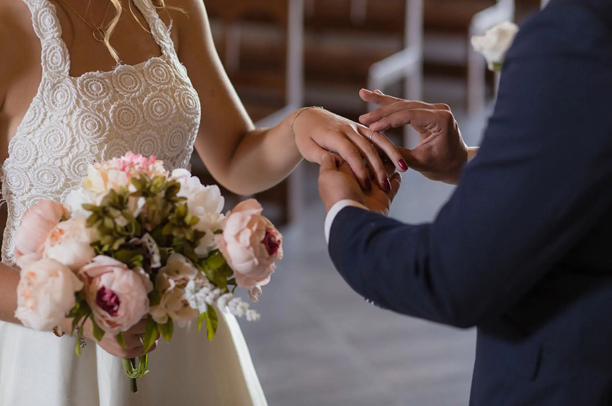 Groom placing a ring on the bride's finger during a chapel wedding ceremony at Bahia Principe Akumal, Tulum