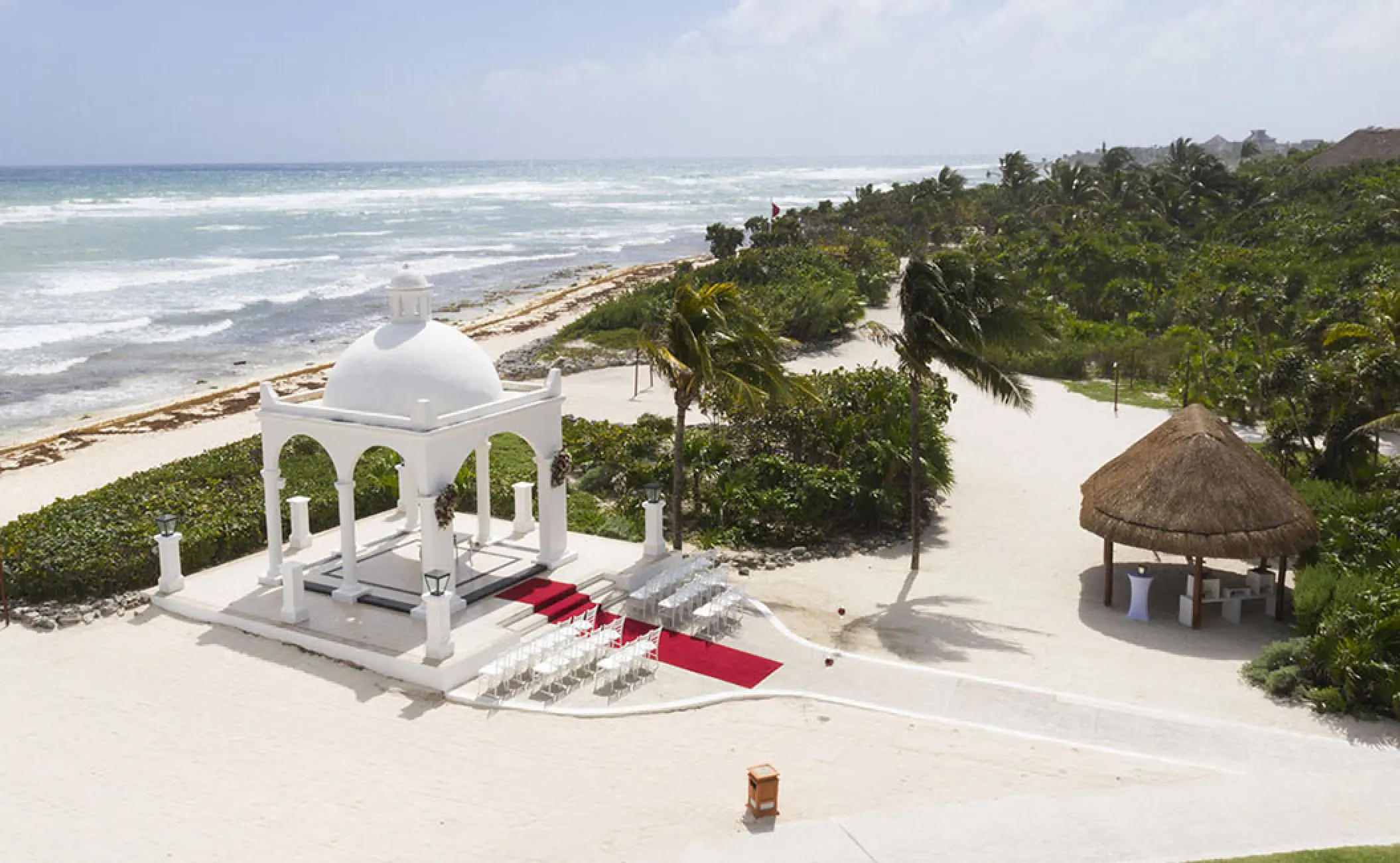 White oceanfront wedding gazebo ceremony setup with red carpet at Bahia Principe Akumal, Tulum