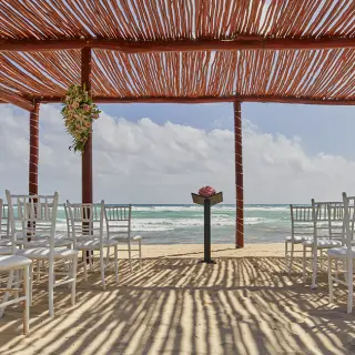 Beachfront wedding ceremony under a wooden pergola at Bahia Principe Luxury Akumal, Tulum