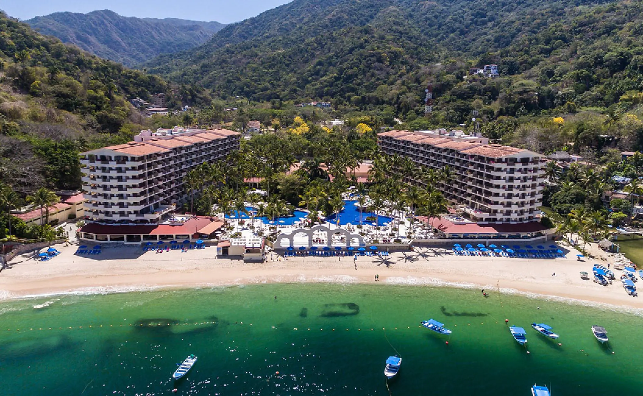 Aerial view of Barcelo Puerto Vallarta and its beach nestled against lush green mountains, Puerto Vallarta