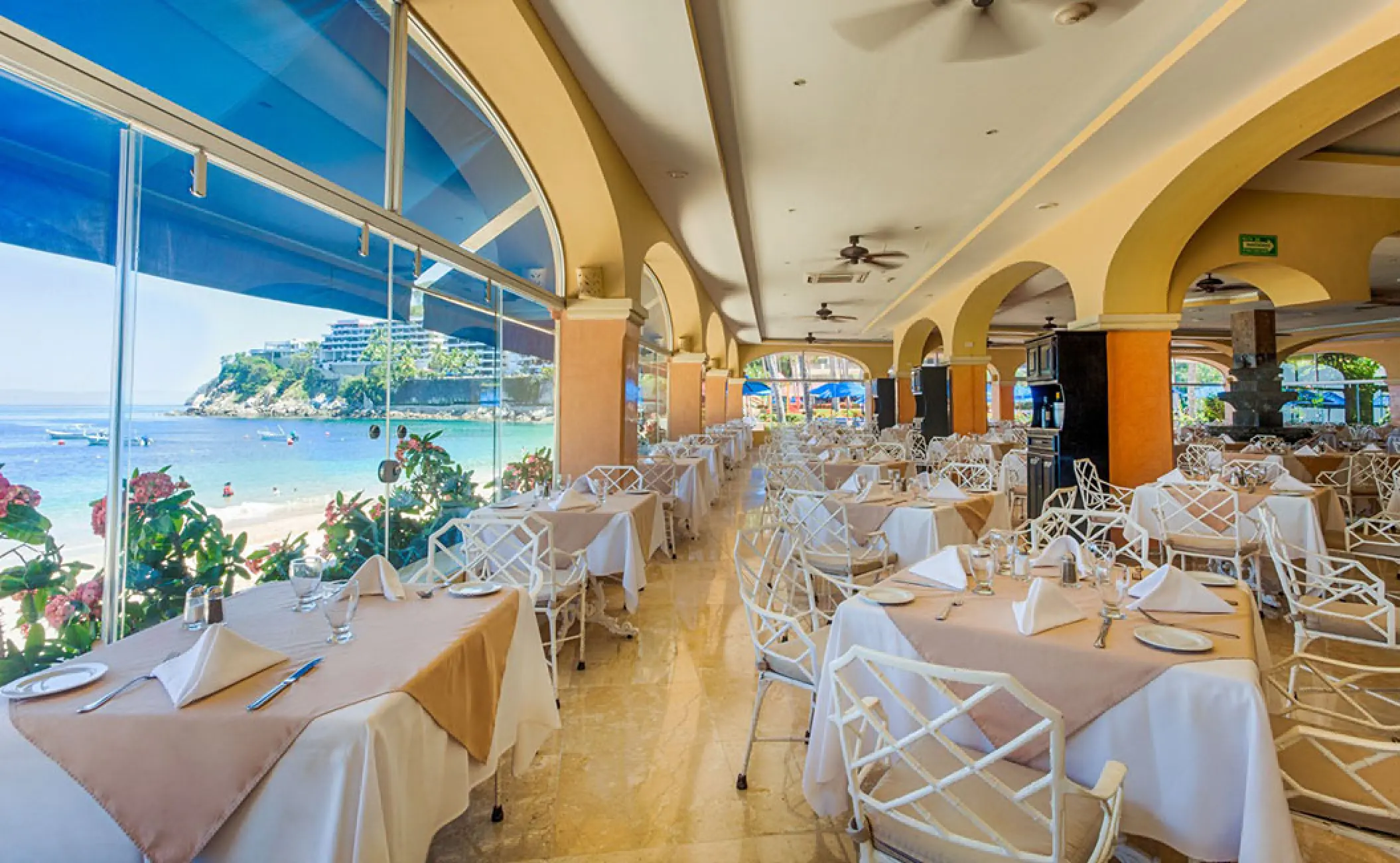 Buffet restaurant with ocean views and white chairs at Barcelo Puerto Vallarta
