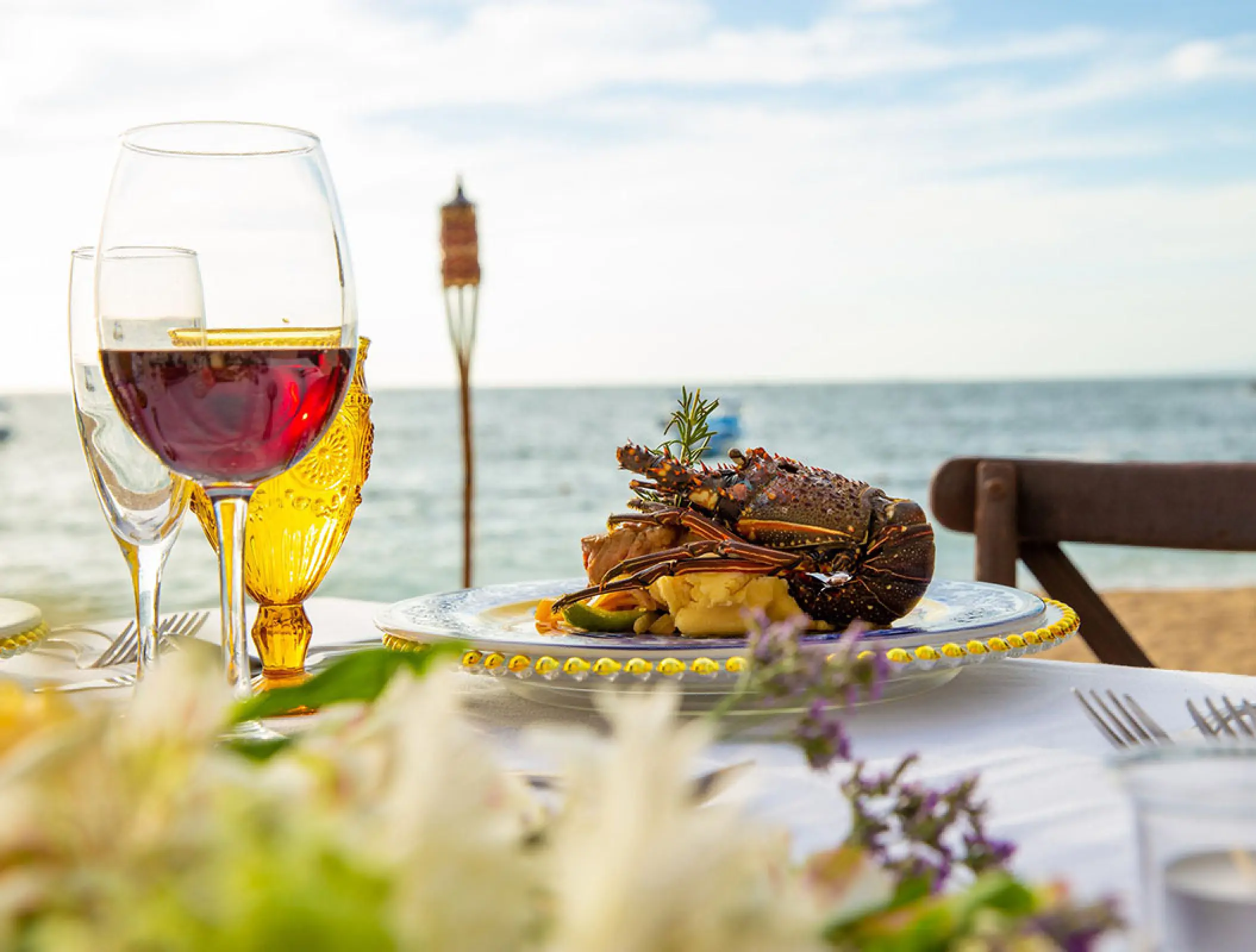 Lobster dish and red wine at a beachfront restaurant table at Barcelo Puerto Vallarta