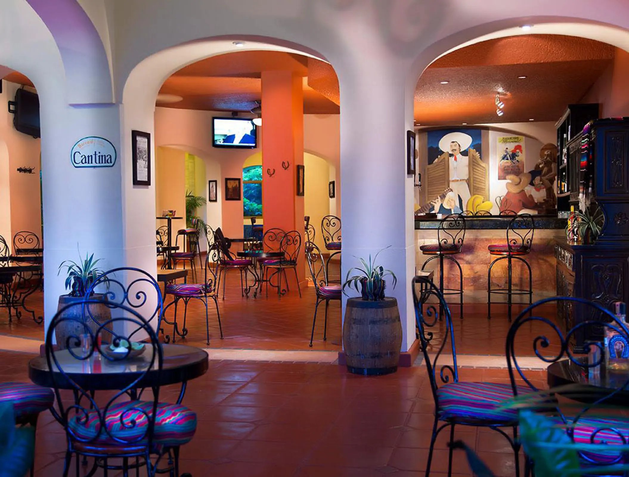 Mexican cantina restaurant with wrought iron furniture and arched pillars at Barcelo Puerto Vallarta