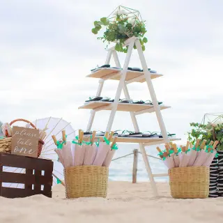 Wedding guest favors station with fans and umbrellas on the beach at Barcelo Puerto Vallarta