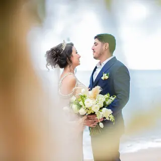 The bride and groom embracing on the beach at Barcelo Puerto Vallarta