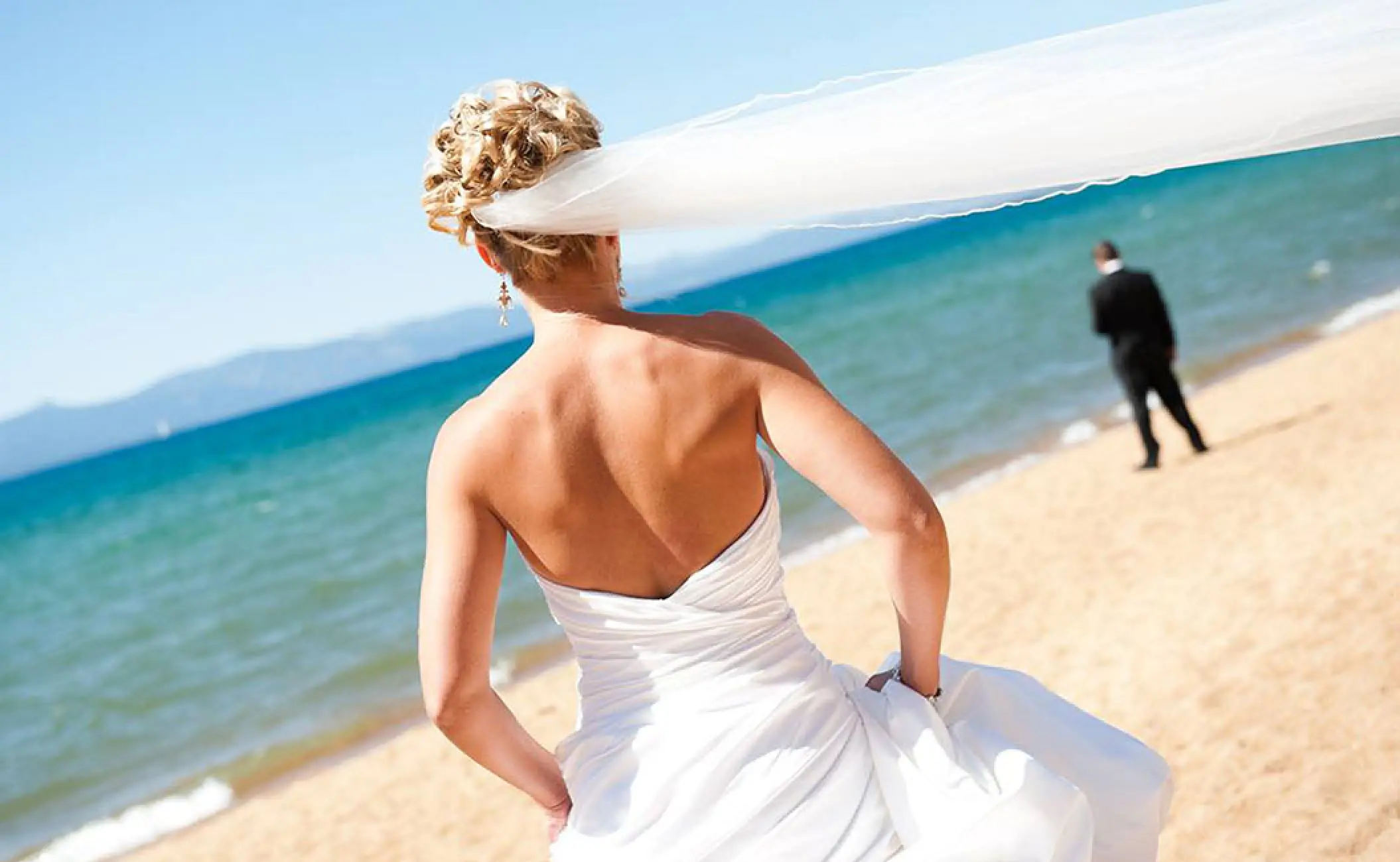 Bride's veil blowing in the wind during a beach wedding at Barcelo Puerto Vallarta