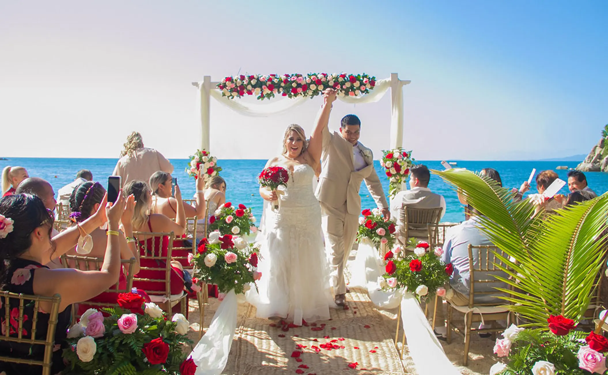 The couple celebrating after their beach ceremony at Barcelo Puerto Vallarta