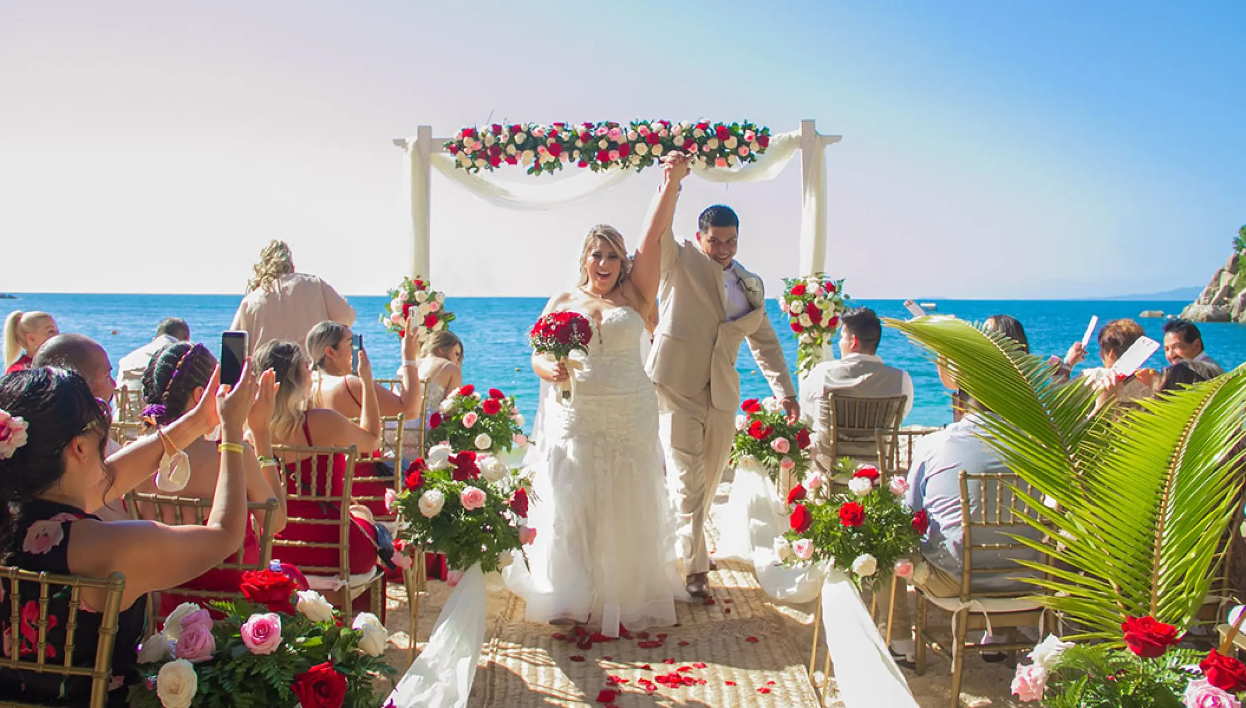 The couple celebrating after their beach ceremony at Barcelo Puerto Vallarta