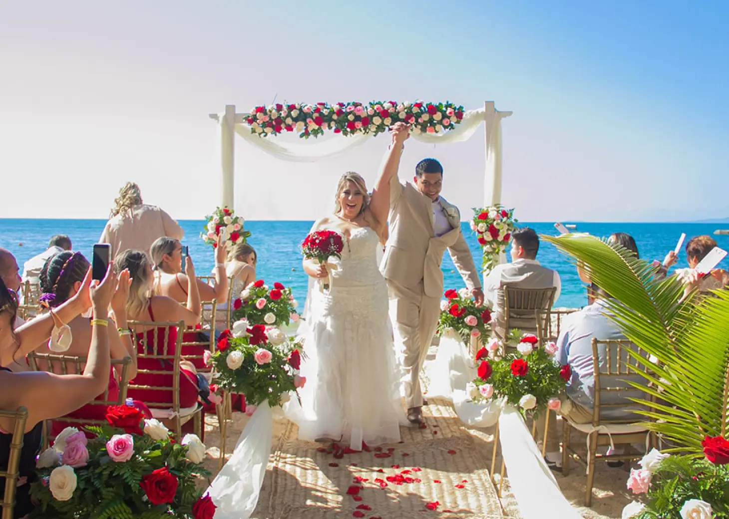The couple celebrating after their beach ceremony at Barcelo Puerto Vallarta