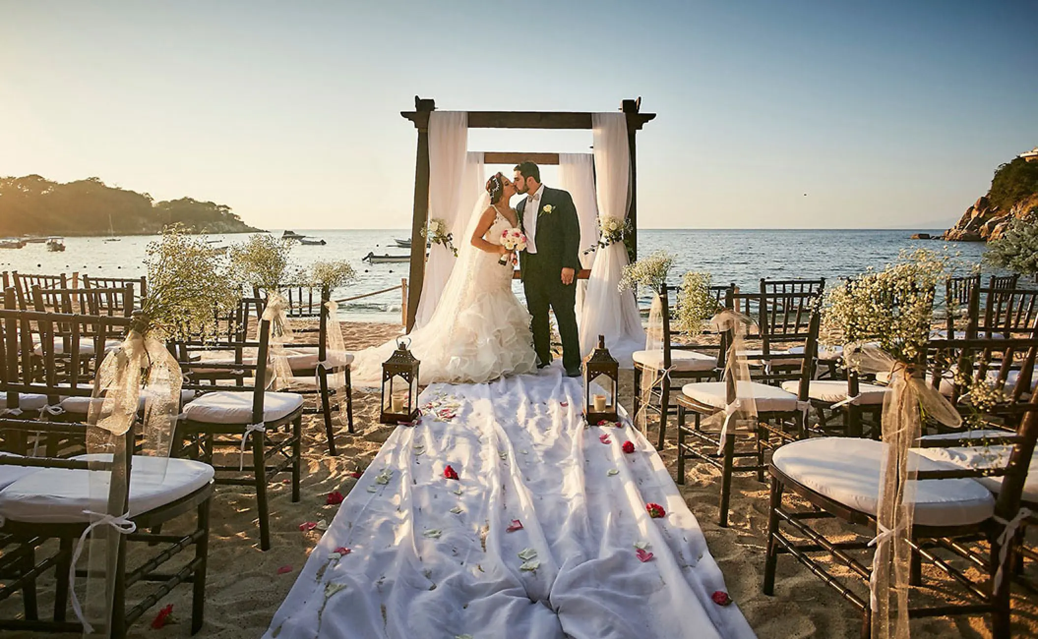 Bride and groom kissing at a beach ceremony at Barcelo Puerto Vallarta