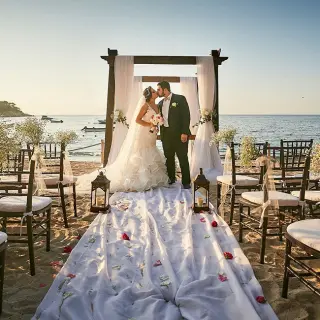 Bride and groom kissing at a beach ceremony at Barcelo Puerto Vallarta