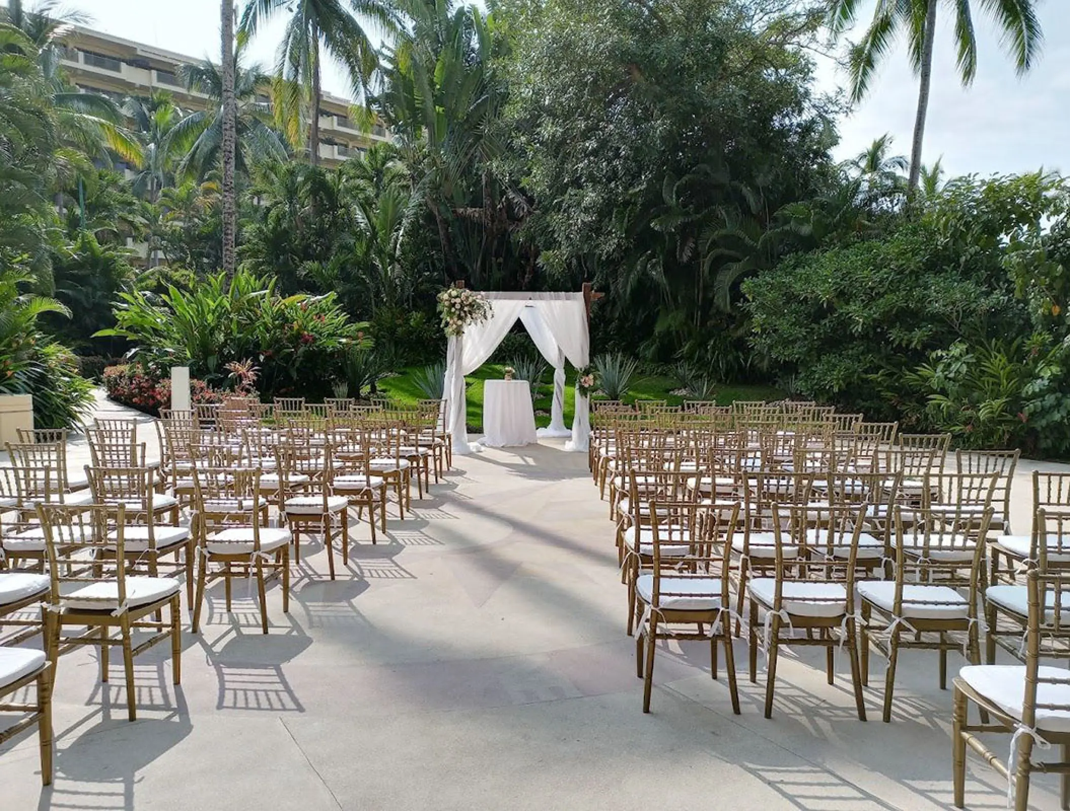 La Plazita wedding ceremony setup with gold chairs and white arbor at Barcelo Puerto Vallarta, Puerto Vallarta