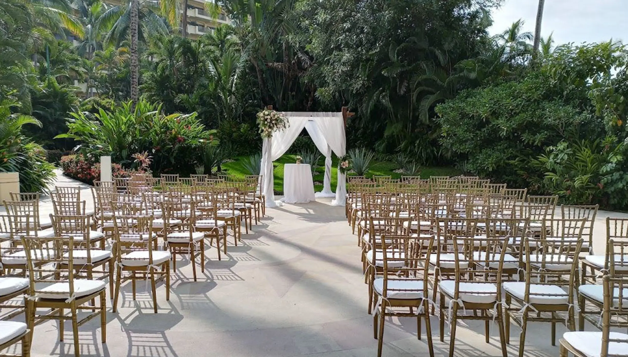 La Plazita wedding ceremony setup with gold chairs and white arbor at Barcelo Puerto Vallarta, Puerto Vallarta