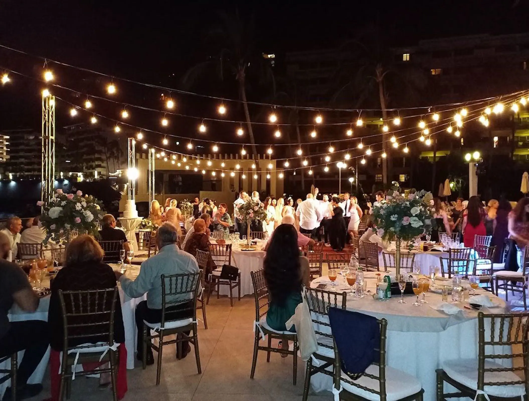 Outdoor wedding reception with string lights at night on the terrace at Barcelo Puerto Vallarta