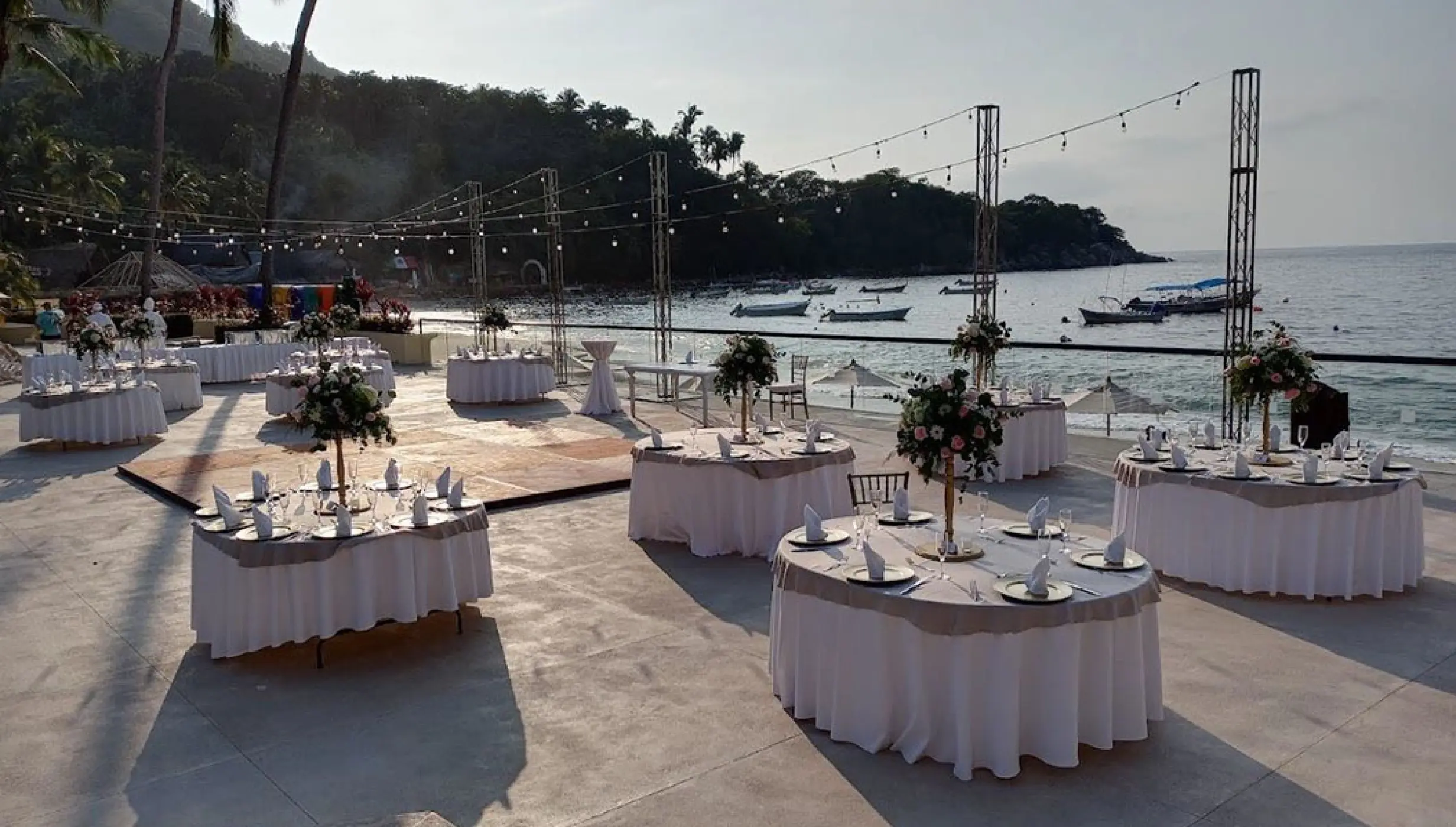 Terrace wedding reception with floral centerpieces overlooking the ocean at Barcelo Puerto Vallarta