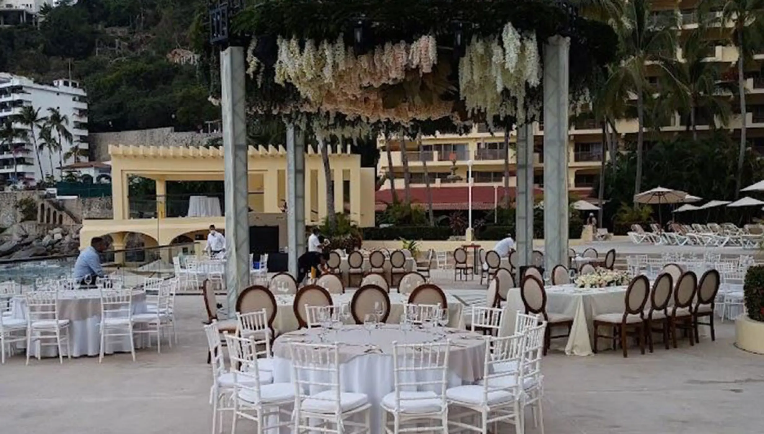 Outdoor wedding reception at Barcelo Puerto Vallarta, featuring a floral gazebo and white tables
