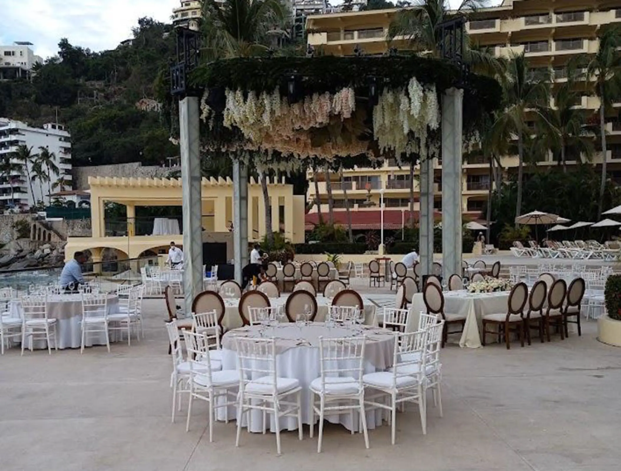 Outdoor wedding reception at Barcelo Puerto Vallarta, featuring a floral gazebo and white tables