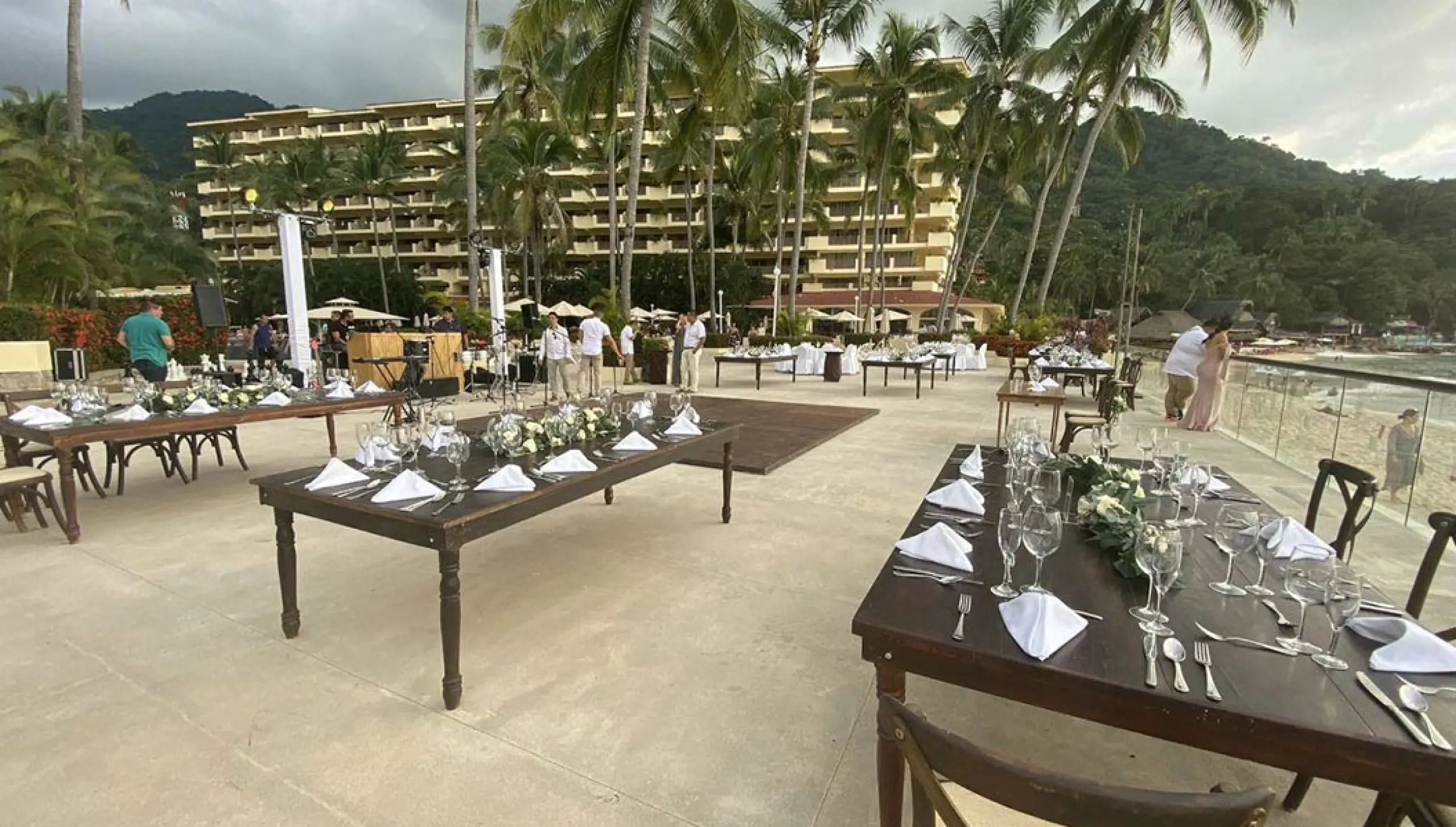 Outdoor terrace wedding reception with wooden tables at Barcelo Puerto Vallarta