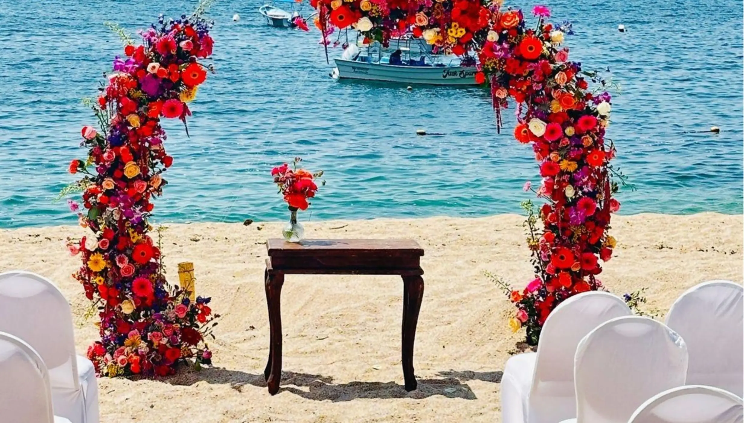 Colorful floral arch for a beach ceremony at Barcelo Puerto Vallarta