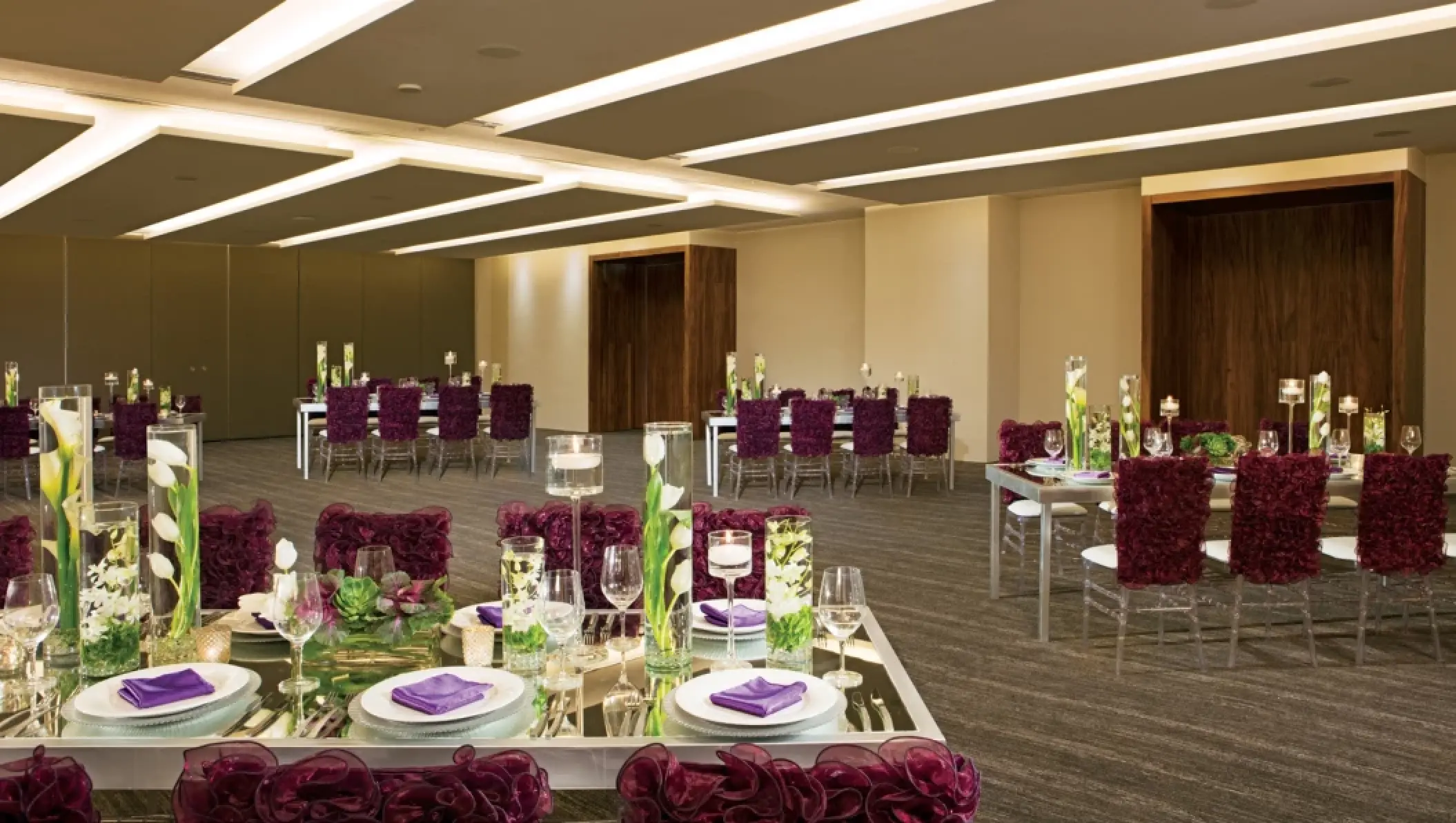 Indoor wedding reception setup with purple decor at Breathless Cabo San Lucas