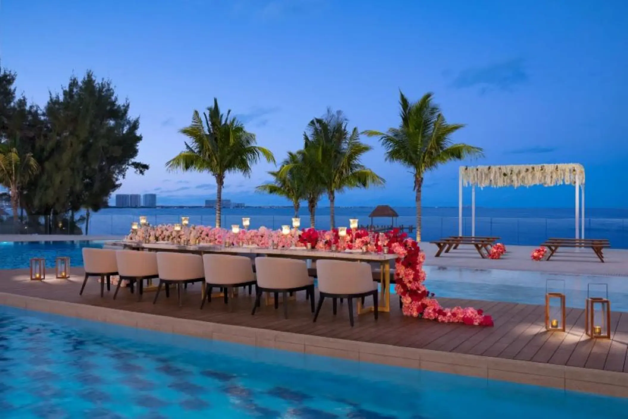 Poolside wedding reception setup with floral table runner at Breathless Cancun Soul, Cancun