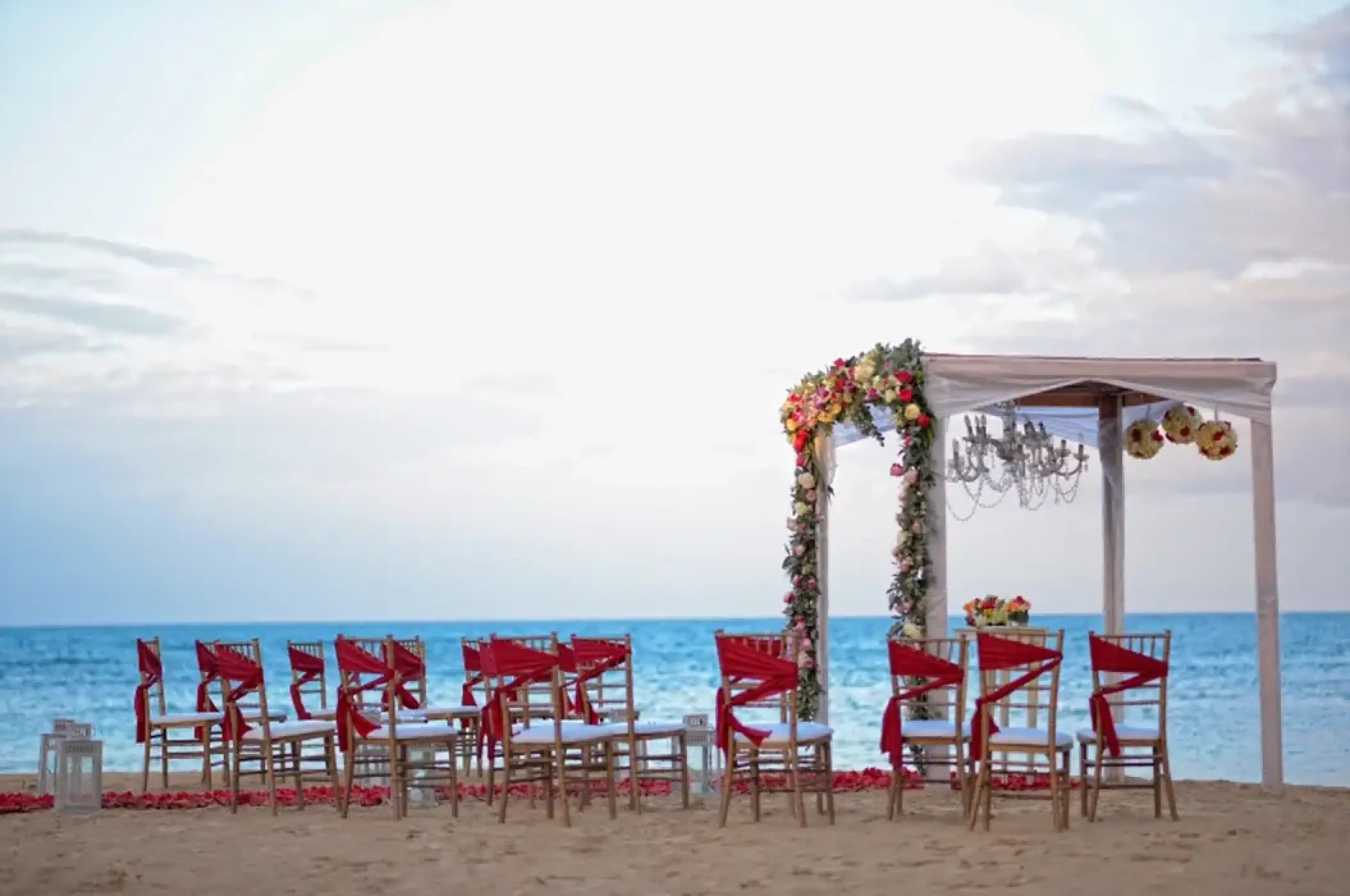 Beachfront wedding ceremony with red sashes at Breathless Punta Cana, Punta Cana